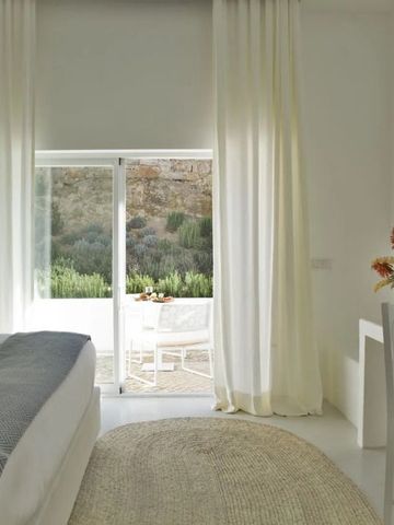Elegantes Zimmer mit großen Vorhängen und Blick auf die Terrasse