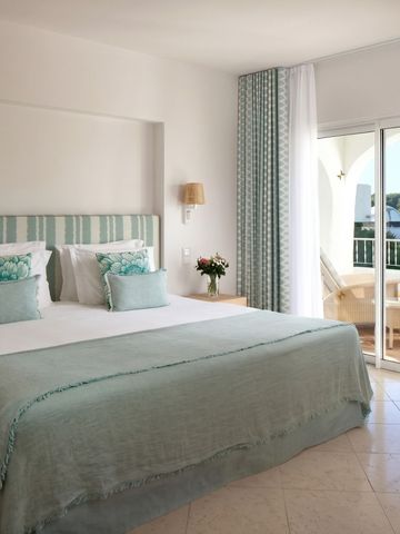 Geräumiges Zimmer mit Balkonblick auf gepflegte Gartenanlagen im Vila Vita Parc.