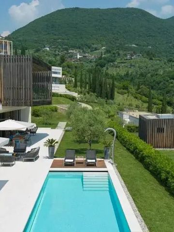 Poolbereich mit Liegen und einem Panoramablick auf umliegende Hügel und moderne Architektur