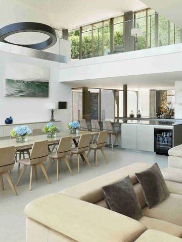 Geräumiges Wohnzimmer mit modernem Essbereich und großen Fenstern