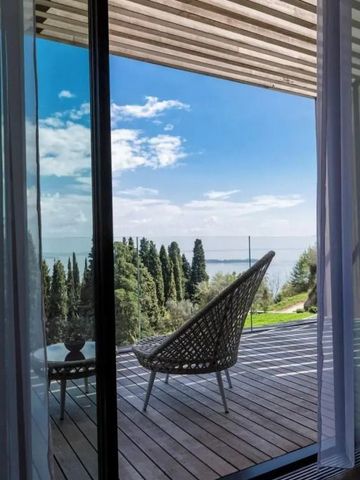 Terrasse mit Blick auf den See und stilvollem Stuhl unter blauem Himmel