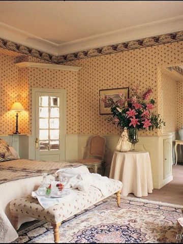 Charmantes Schlafzimmer mit Blumenmuster und gemütlicher Atmosphäre