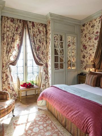 Helles Schlafzimmer mit stilvollen Blumendekorationen und gemütlichem Sessel