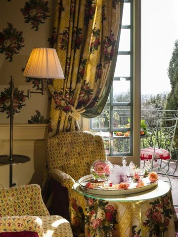 Gemütliche Sitzecke mit floralem Dekor und Blick auf den Balkon