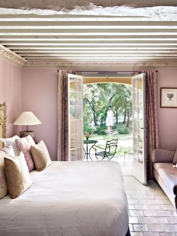 Elegantes Schlafzimmer mit Himmelbett und Blick auf den Garten