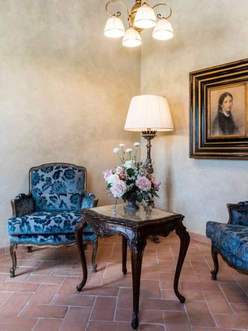 Kleiner Lounge-Bereich in Villa Petriolo mit stilvollen blauen Sesseln und Kunstwerk