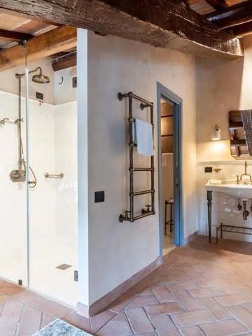 Rustikales Badezimmer mit freiliegenden Holzbalken und Glasdusche