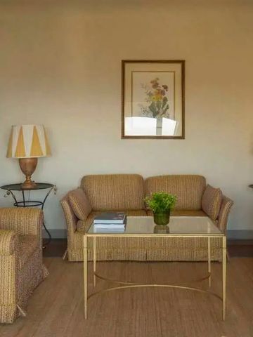 Gemütliche Sitzecke mit Rattanmöbeln und eleganten Lampen in der Villa San Michele