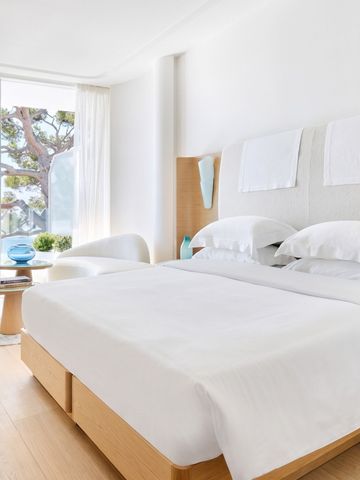 Helles Zimmer mit großem Fenster und Baumblick