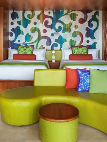 Hotelzimmer mit zwei Betten und farbenfroher Wanddekoration