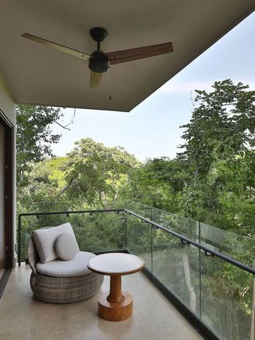Terrasse mit Blick auf den üppigen Wald, Sessel und Tisch vorhanden