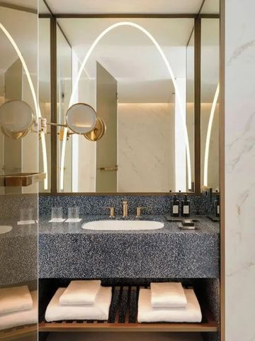 Luxuriöses Marmorbadezimmer mit großem Spiegel und eleganter Beleuchtung