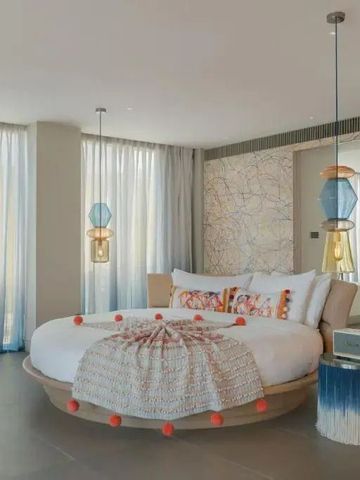Rundes Bett in einem lichtdurchfluteten, eleganten Zimmer