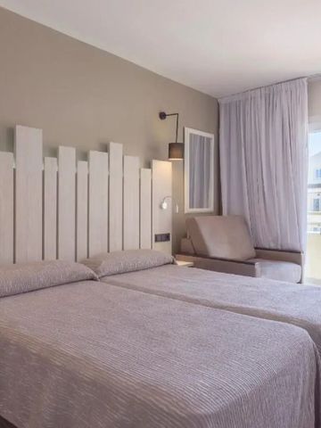 Helles Hotelzimmer mit zwei Einzelbetten und Balkon