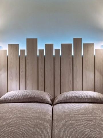 Doppelbett mit stilvollem Kopfteil und Leselampen