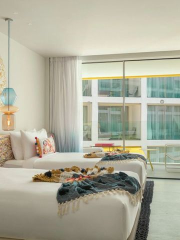 Helles Zimmer mit zwei Betten und großer Fensterfront