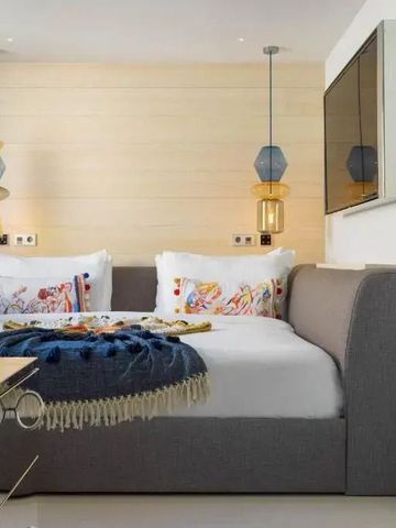 Modernes Hotelzimmer mit stilvollen Hängelampen und dekorativen Kissen.