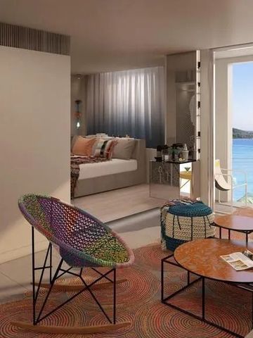 Gemütliches Zimmer mit Blick aufs Meer und bunten Möbeln.