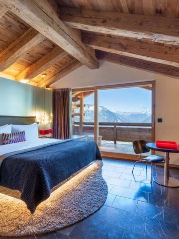 Hotelzimmer im alpinen Stil mit Panoramafenstern und Bergblick
