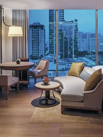 Elegantes Hotelzimmer mit Sitzecke und Ausblick auf die Stadt
