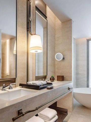 Modernes Badezimmer mit eleganter Badewanne und großem Spiegel im Waldorf Astoria Bangkok