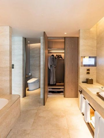 Geräumiges Badezimmer mit Badewanne und Warmlichtbeleuchtung im Waldorf Astoria Bangkok