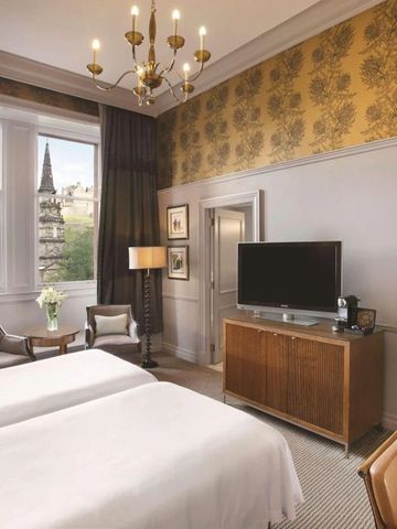Hotelzimmer mit Doppelbetten und Blick auf historische Gebäude