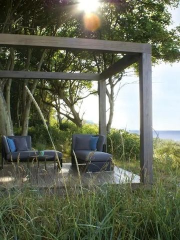 Gemütliche Lounge mit Meerblick umgeben von Bäumen und Natur
