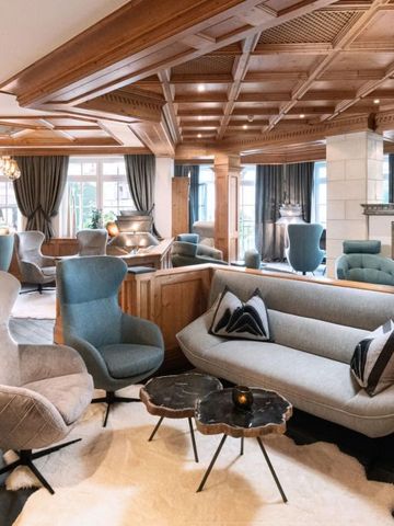 Gemütliche Lounge mit stilvollen Sitzgelegenheiten und Holzdecke.