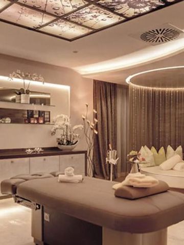 Luxuriöser Spa-Raum mit Massagebett und stimmungsvoller Beleuchtung