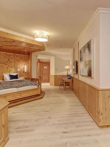 Geräumiges Hotelzimmer mit Holzverkleidung und gemütlicher Atmosphäre
