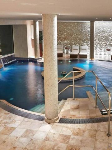 Innenansicht eines luxuriösen Spabereichs mit Pool und Liegestühlen