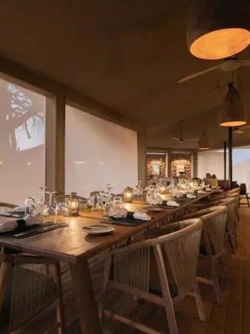 Elegant gedeckter Tisch im gemütlichen Speisebereich mit Kerzenschein bei Dämmerung