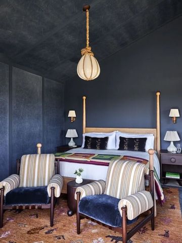 Modernes Schlafzimmer in dunkler Farbgestaltung mit Designer-Leuchte