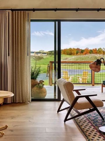 Hotelzimmer mit eleganter Einrichtung und Blick auf Terrasse und Natur.