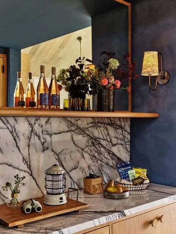 Elegante Bar mit Marmorverkleidung und dekorierten Flaschen.
