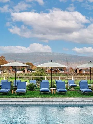 Sonnenliegen mit Sonnenschirmen am Pool mit Bergpanorama
