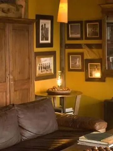 Gemütlicher Innenraum mit Ledersofa und Dekorationen an gelber Wand