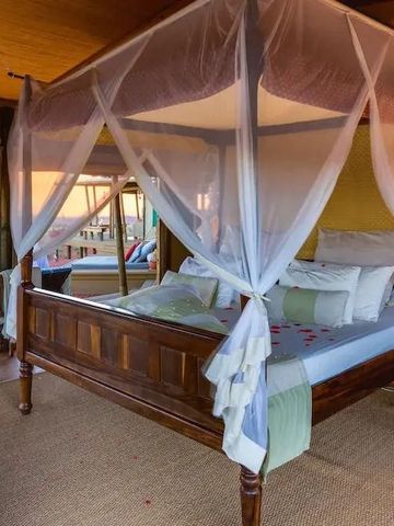 Luxuriöses Himmelbett mit Baldachin in einem elegant eingerichteten Zimmer.