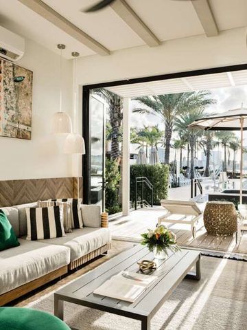 Lounge im Freien mit Zugang zu einem eleganten Poolbereich und Palmen