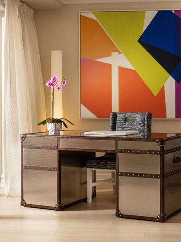 Designer-Schreibtisch mit farbigem Kunstwerk im Hintergrund
