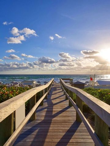 Holzsteg führt zum Strand mit Sonnenaufgang im Hintergrund