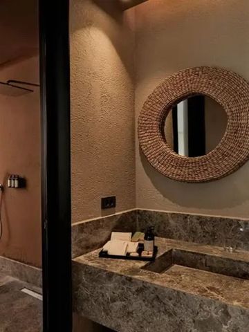 Modernes Badezimmer mit Steinwaschbecken und runden Spiegeln