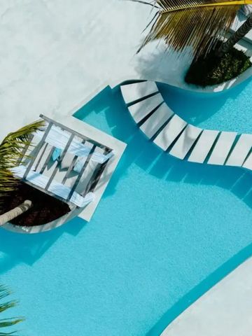 Pool mit geschwungenen Formen und Palmen im Hintergrund