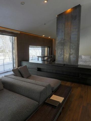 Luxuriöse Suite mit modernem Design und großem Fenster mit Schneelandschaft.