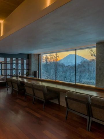 Bar mit Panoramablick auf verschneite Landschaft und Sonnenuntergang.