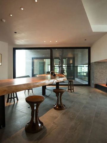 Eleganter Gemeinschaftsraum mit modernem Holztisch und Hockern im Zaborin Ryokan.