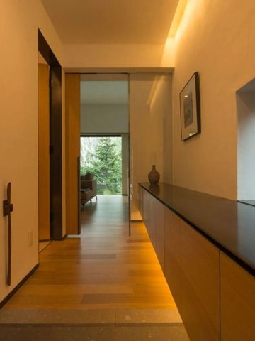 Eleganter Flur mit modernem Design und Blick auf einen Wohnbereich.