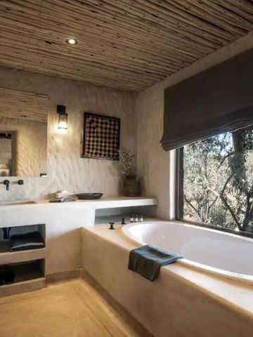Luxuriöses Badezimmer mit großer Badewanne und Blick auf die Natur bei Zannier Omaanda
