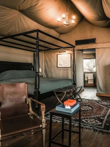 Luxuriöses Zeltzimmer mit Himmelbett und Ledersesseln